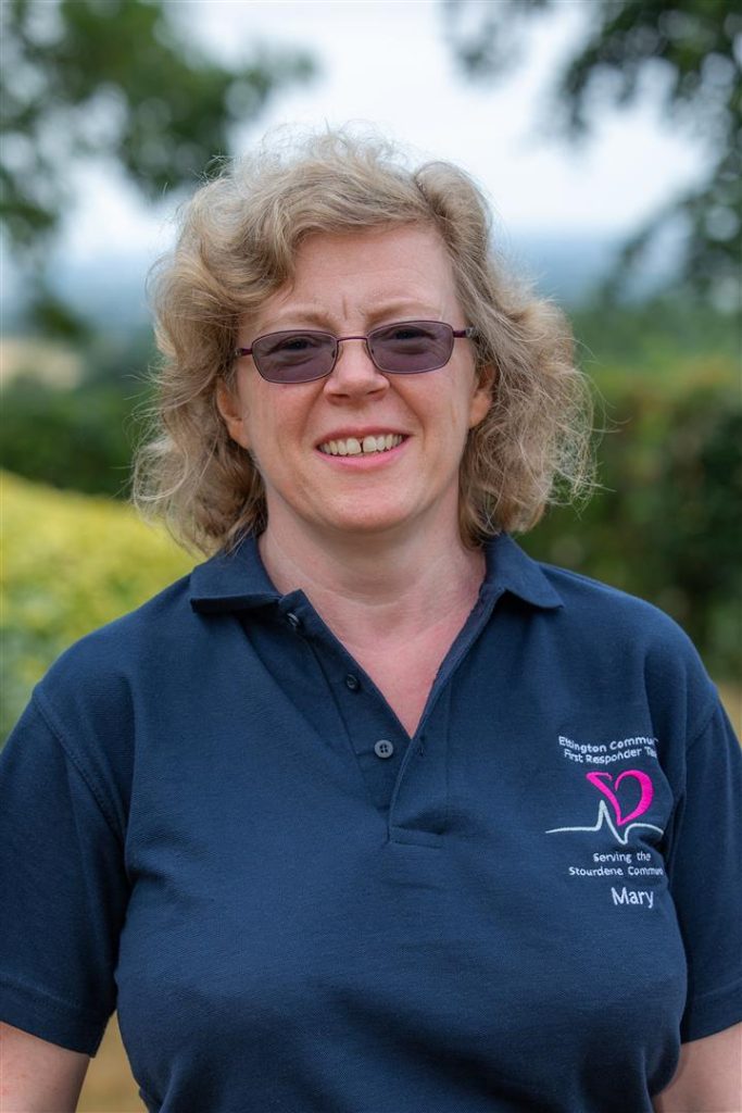 Picture of Mary smiling in a blue t-shirt